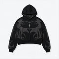 Black streetwear hoodie with bold gray abstract flame design and small cross detail on chest