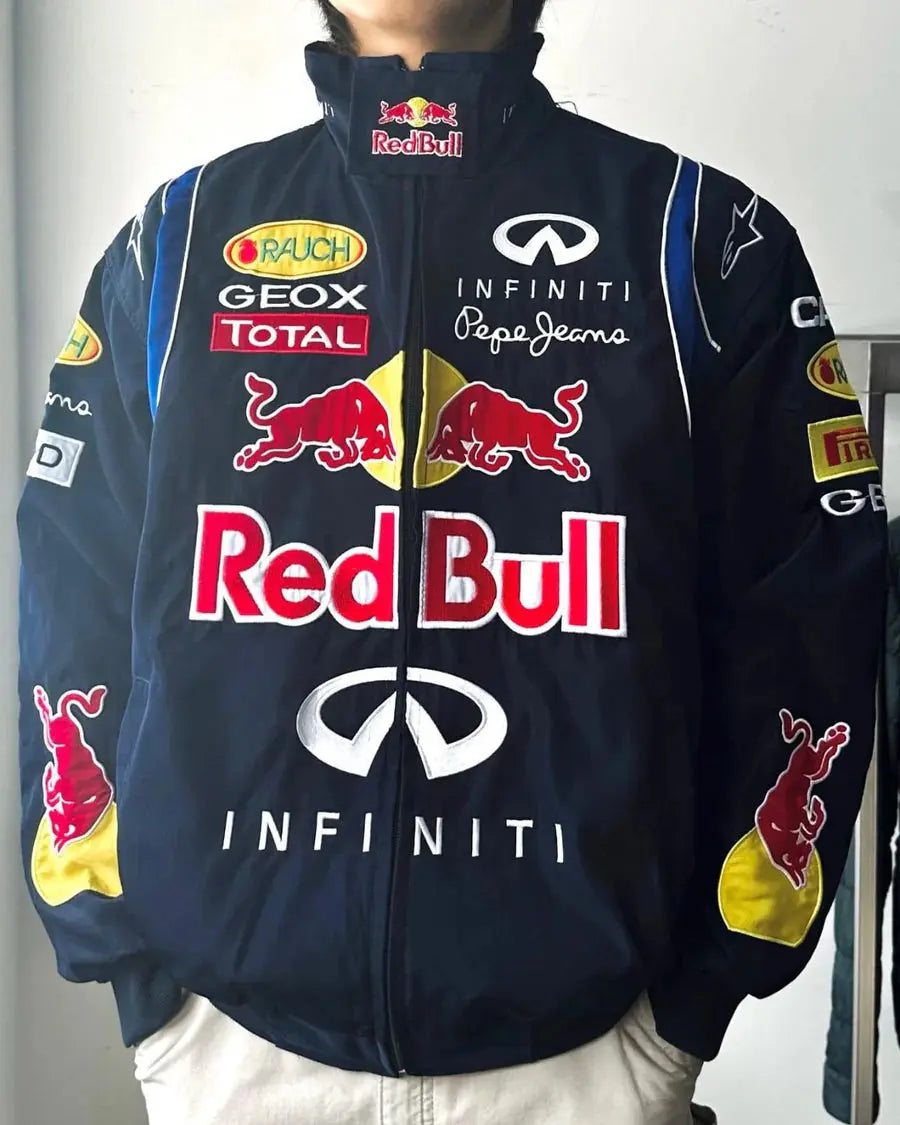 Person wearing navy racing jacket with bold Red Bull, Infiniti, and motorsport sponsor patches