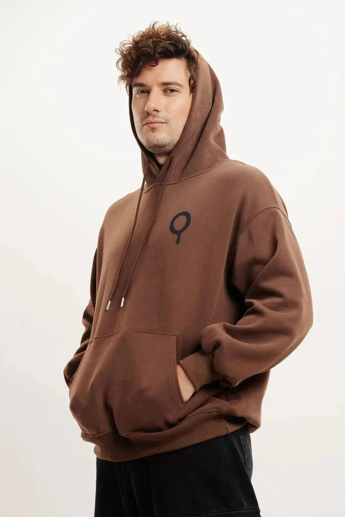 Man wearing brown oversized streetwear hoodie with front logo and kangaroo pocket
