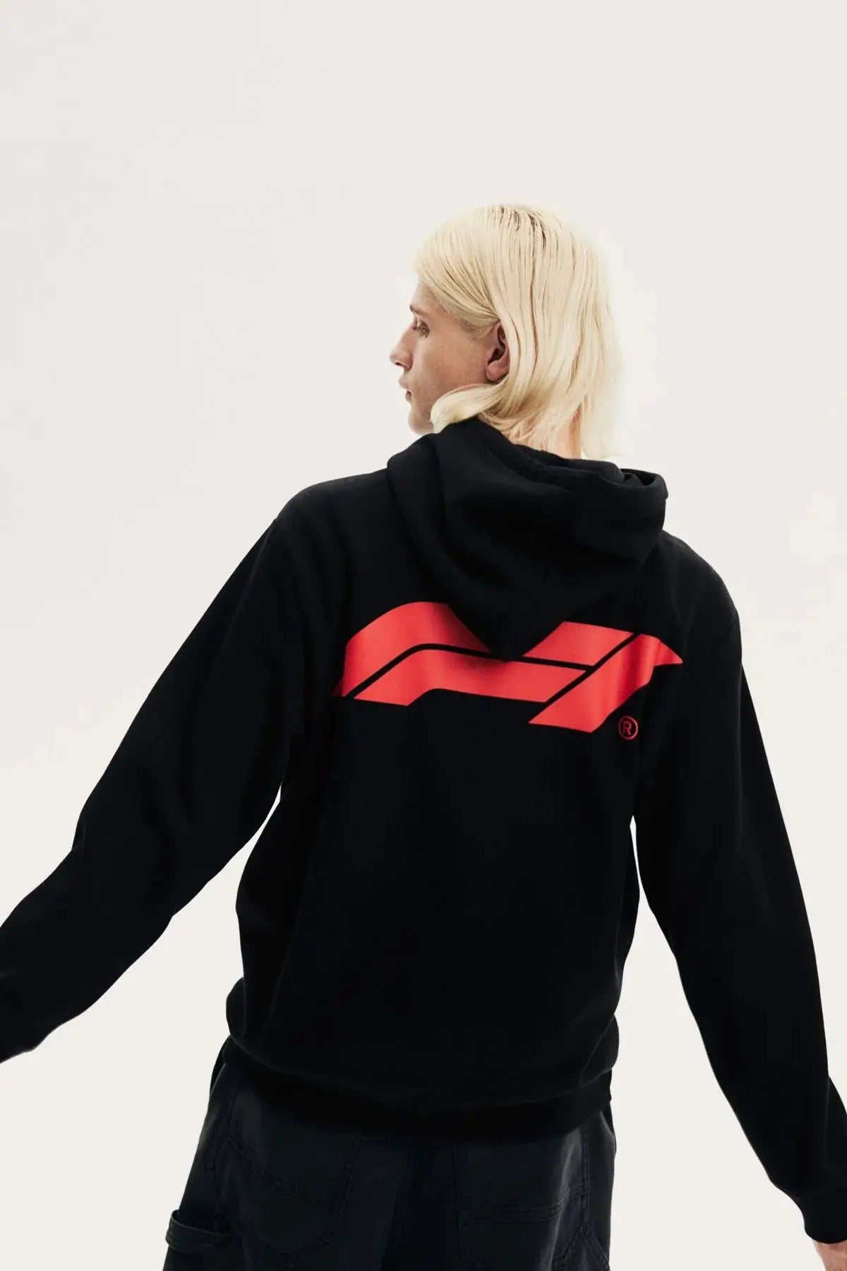Back view of a person wearing a black fleece hoodie with a bold red racing graphic design.