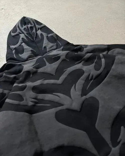 Black hoodie with bold tribal graphic pattern, modern streetwear detail closeup
