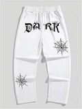 White streetwear baggy pants with black gothic 'DARK' text and spiderweb print graphics
